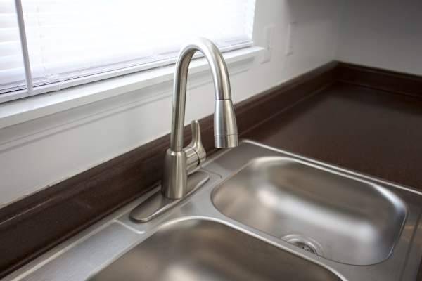 A modern kitchen sink with a chrome faucet.